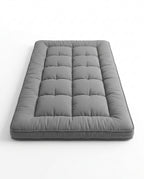 Grey quilted foldable floor comfort mattress, studio shot on white