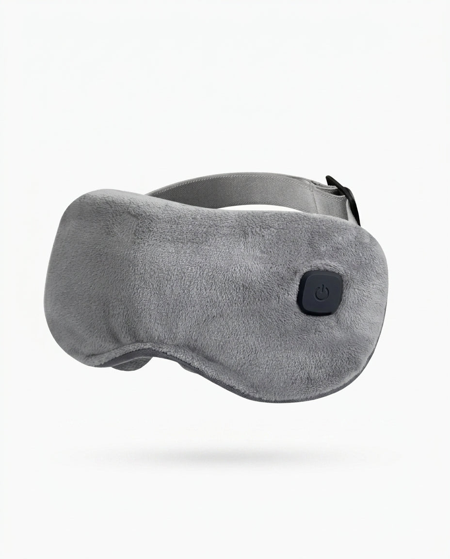 Grey plush heated eye massager mask with power button, studio shot on white