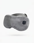 Grey plush heated eye massager mask with power button, studio shot on white