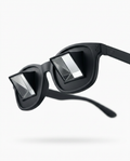 Black prism bed reading glasses with angled mirror lenses, studio shot on white