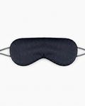 Black silk sleeping eye mask with grey elastic strap, studio shot on white