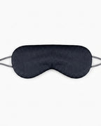 Black silk sleeping eye mask with grey elastic strap, studio shot on white