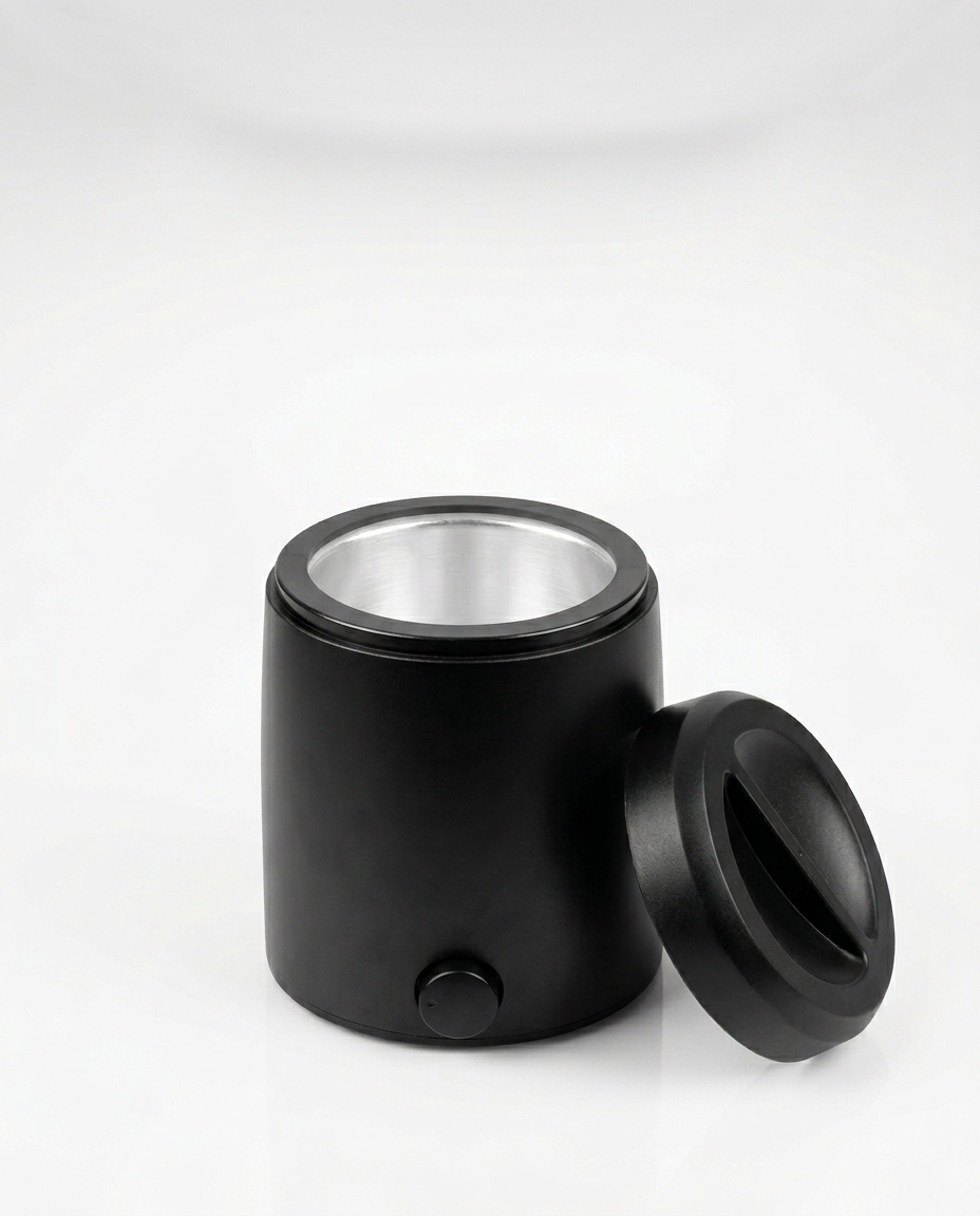 Black home wax warmer with lid off and aluminum well, studio shot on white