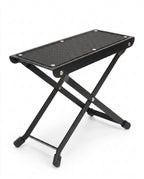 Black folding footrest platform with non-slip top and X-frame legs, on white
