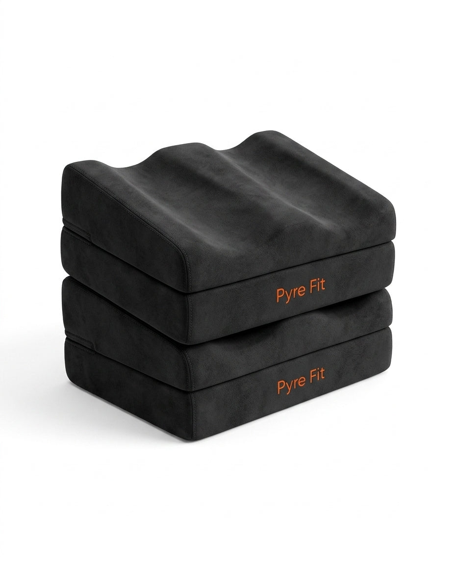 Stacked black contoured foam foot rest cushions with orange Pyre Fit logo on white