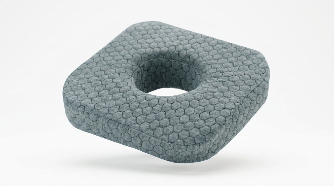 Grey honeycomb ear piercing pillow with center cavity, studio shot on white