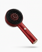 Red handheld scalp massage comb with silicone bristles, studio packshot