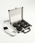 Hot stone massage set with black basalt stones in an aluminum case, on white