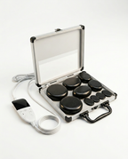 Hot stone massage set with black basalt stones in an aluminum case, on white