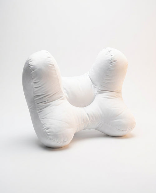White butterfly-shaped ergonomic support pillow with central cradle, studio on white