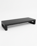 Black ergonomic monitor stand riser for desk, studio shot on white