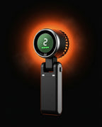 Black handheld cooling fan with digital speed display on a dramatic orange glow background