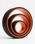 Three nested black and orange back stretching rollers in graduated sizes