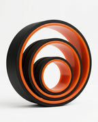Three nested black and orange back stretching rollers in graduated sizes