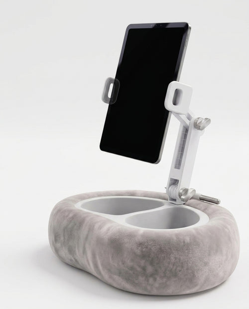 Grey velvet tablet pillow stand with adjustable arm holding a tablet, studio shot