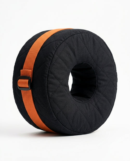 Black quilted donut ankle cushion with orange adjustable strap on white