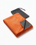 Folded orange yoga towel with gray carry pouch, studio shot on white