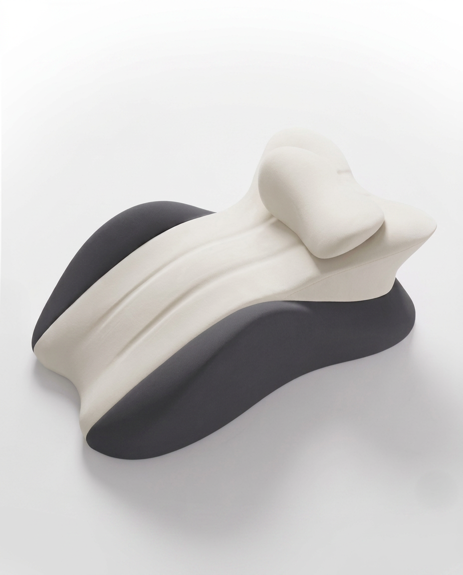 Contoured cervical neck support pillow with cream top and black base on white