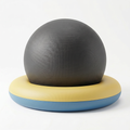 Grey exercise ball cradled in a yellow and blue stability ring base, on white