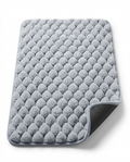 Grey pebble-texture memory foam bath mat with non-slip backing, studio shot
