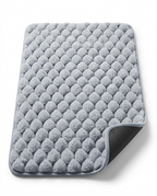 Grey pebble-texture memory foam bath mat with non-slip backing, studio shot
