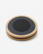 Round wooden rotational balance board with black textured top, studio shot on white