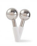 Pair of stainless steel facial ice globes with white handles on white