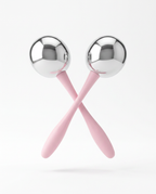 Two stainless steel cooling face rollers with pink handles crossed on white
