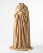 Person fully cocooned in a tan oversized wearable blanket, studio shot