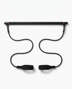 Black Pilates bar kit with resistance bands and foot straps on white