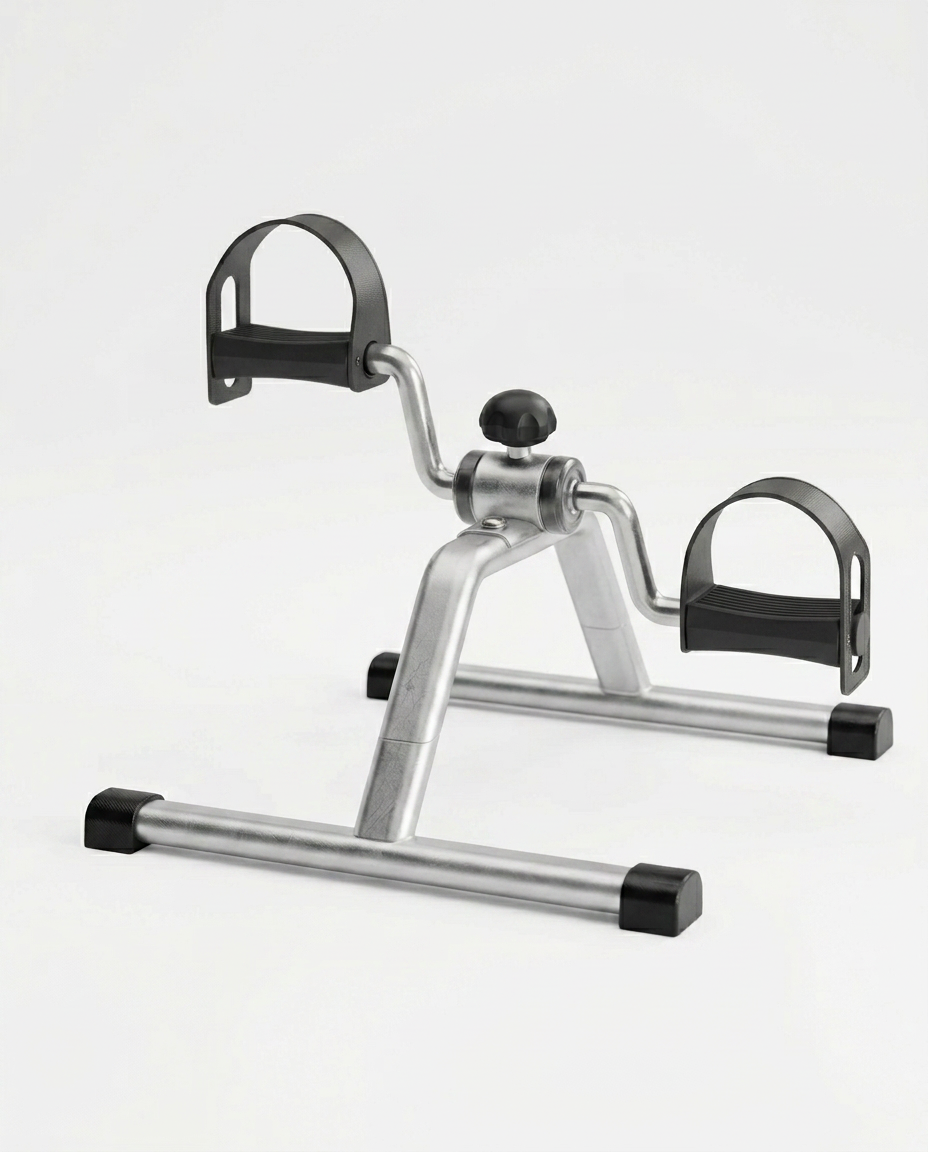 Silver under-desk mini pedal exercise bike with foot straps, studio shot on white