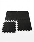 Black EVA foam puzzle exercise mat tiles with interlocking edges on white