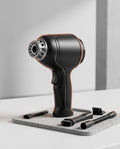 Black cordless handheld vacuum and air blower with nozzle attachments on felt mat
