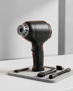 Black cordless handheld vacuum and air blower with nozzle attachments on felt mat