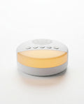 White white-noise sleep machine with warm amber nightlight, on white