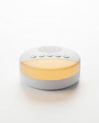 White white-noise sleep machine with warm amber nightlight, on white