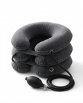 Grey inflatable neck traction pillow with hand air pump on white