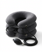 Grey inflatable neck traction pillow with hand air pump on white