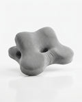 Grey flower-shaped contoured memory foam support pillow with center hole, studio shot on white