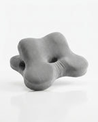 Grey flower-shaped contoured memory foam support pillow with center hole, studio shot on white