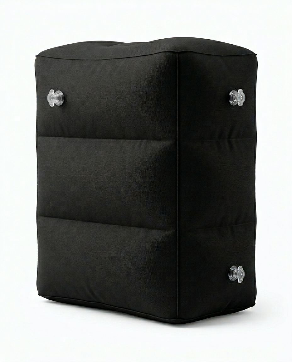 Black inflatable travel footrest pillow with stacked chambers, studio shot on white