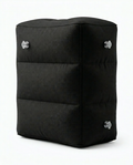 Black inflatable travel footrest pillow with stacked chambers, studio shot on white