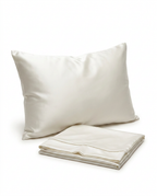 Ivory mulberry silk pillowcase on a pillow with a folded spare, studio shot