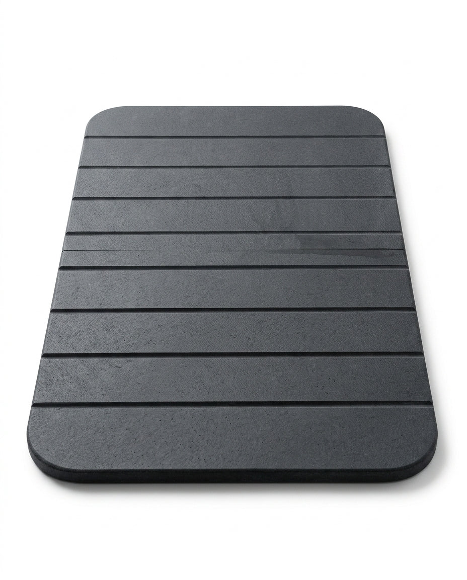 Dark grey grooved diatomite stone bath mat on a white background
