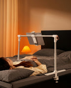 Woman in bed watching a tablet held overhead by the adjustable bed stand