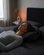 Woman sleeping peacefully in bed using ergonomic neck support pillow in cozy bedroom