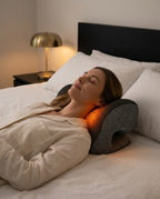 Woman lying in bed with eyes closed, neck resting on the glowing heated pillow