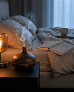 Aromatherapy diffuser releasing mist on a bedside table in a cozy bedroom