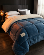 Navy plush winter comforter draped on a made bed in a cozy bedroom