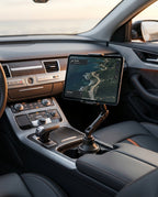 Tablet in a car cup-holder mount showing navigation with a coastal view